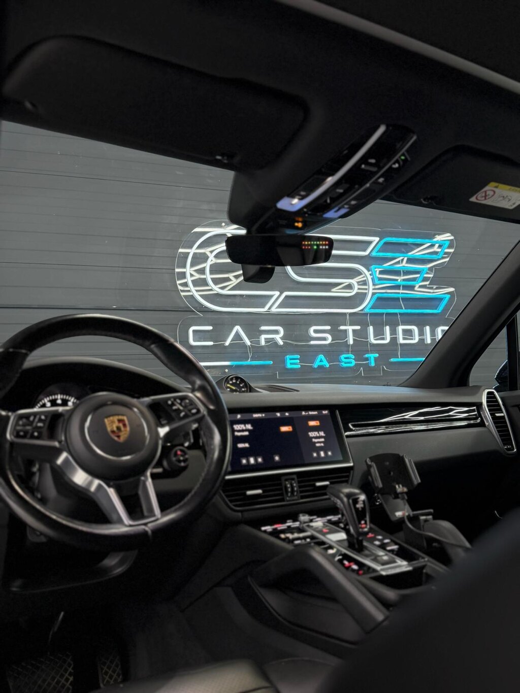 Porsche-interieur met een discreet geplaatst apparaat bij de binnenspiegel