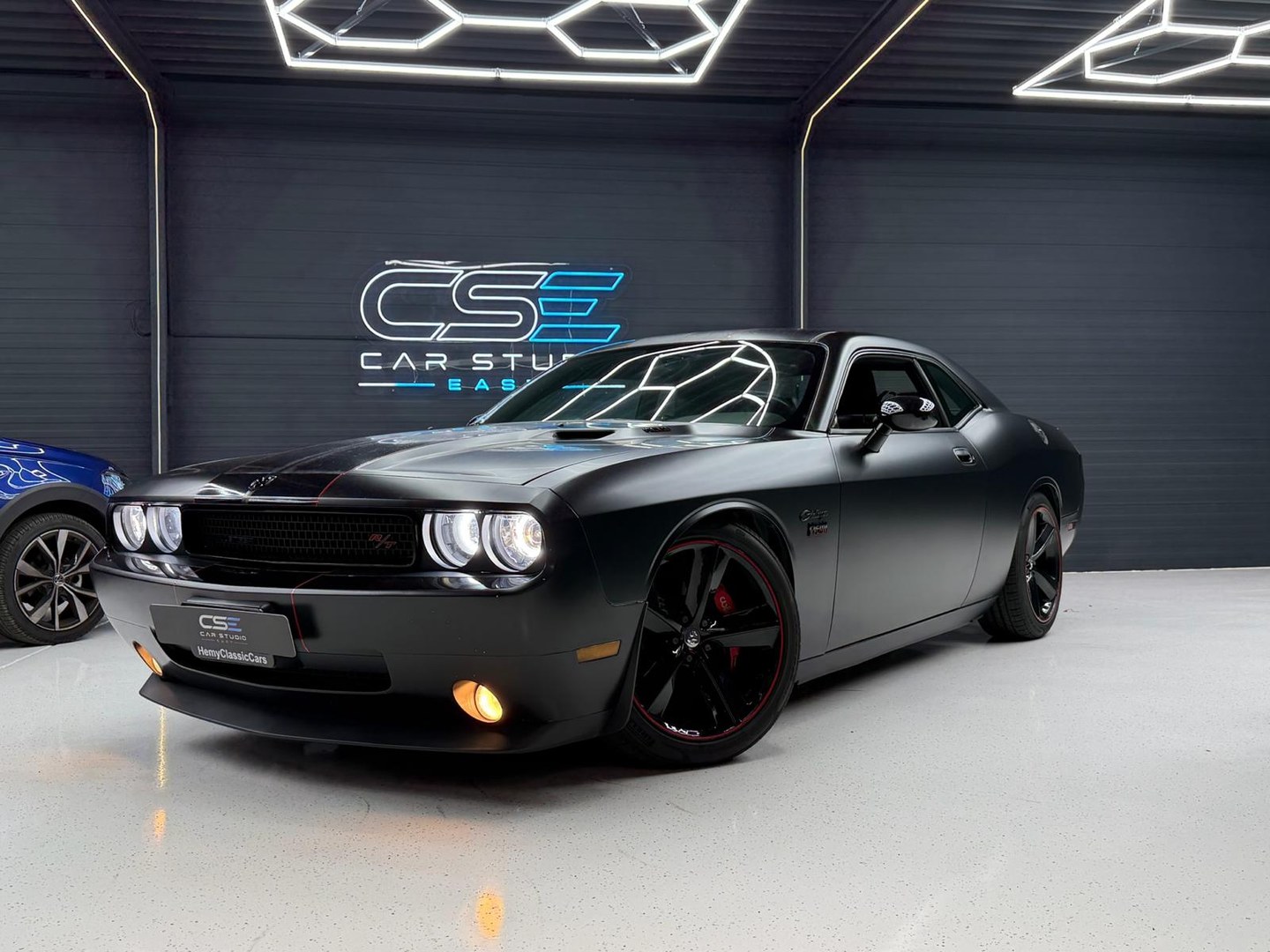 Matzwarte Dodge Challenger vóór de rode en witte striping