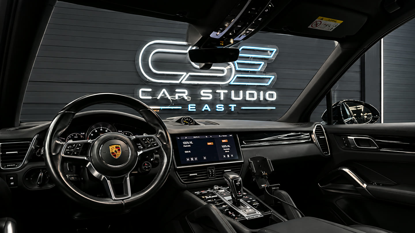 Porsche-interieur met geïntegreerd multimediascherm en het verlichte logo van Car Studio East