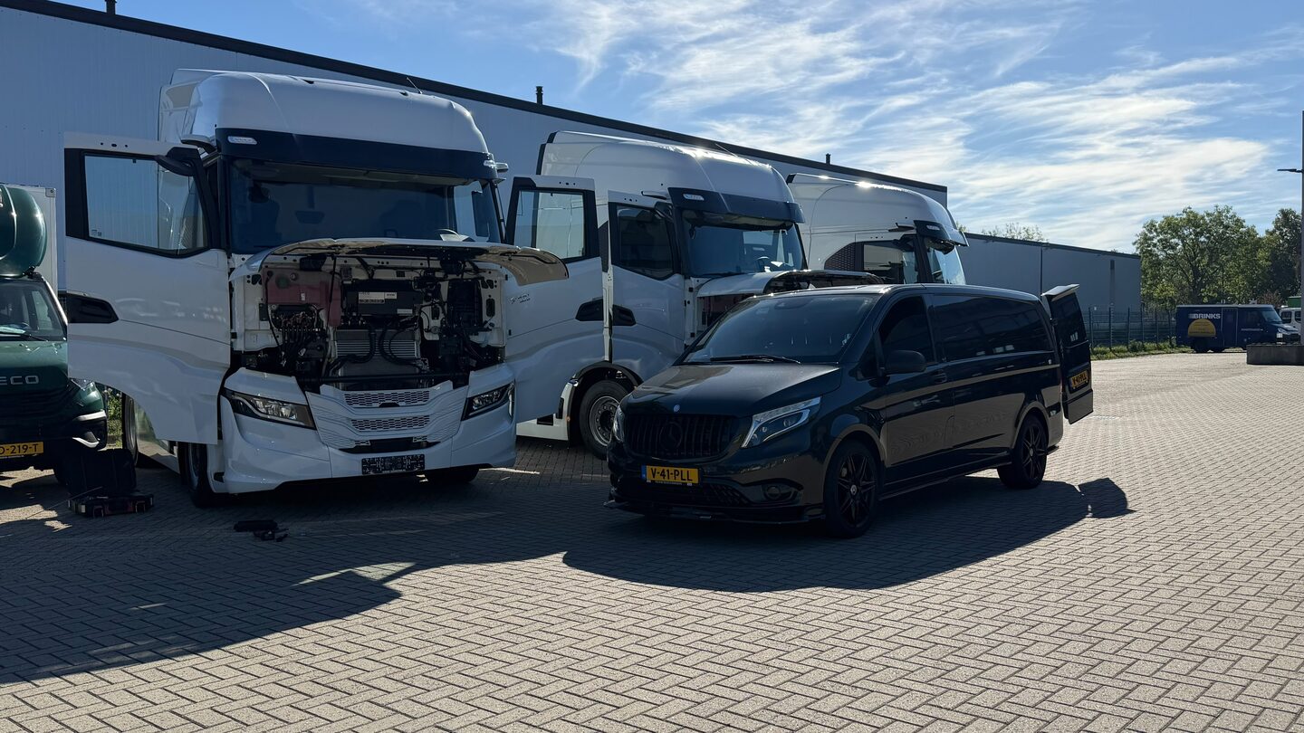 Vrachtwagens en een Mercedes bedrijfswagen op het terrein